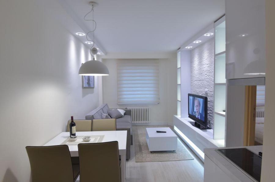 科帕奧尼克的住宿－Konaci Kopaonik Lux Apartmani，客厅配有沙发和带电视的桌子