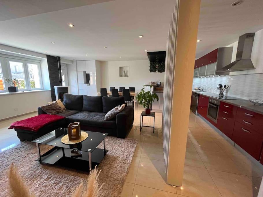 un salon et une cuisine avec un canapé et une table dans l'établissement Maison 3 chambres à Cutry, à Cutry