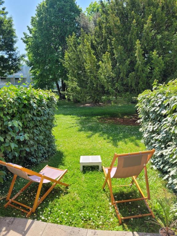 2 chaises et un banc dans la cour dans l'établissement Les voiles de la Baule, à La Baule