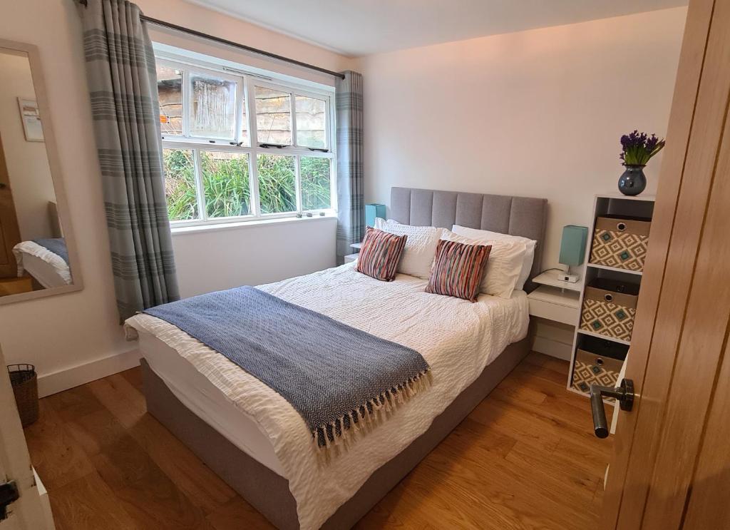 a bedroom with a large bed with a window at Ednyfed Apartment in Nefyn