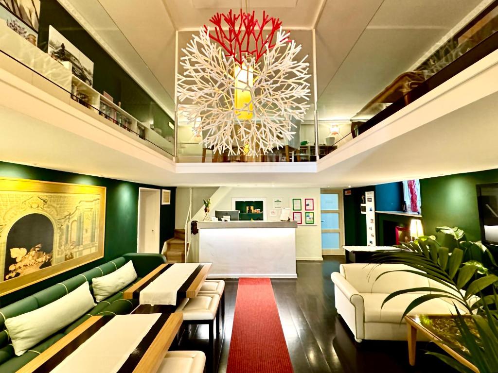 a living room with green furniture and a chandelier at Sorrento Apartments in Sorrento