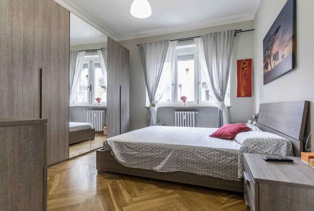um quarto com uma cama grande e 2 janelas em Parco Dora lovely home em Turim