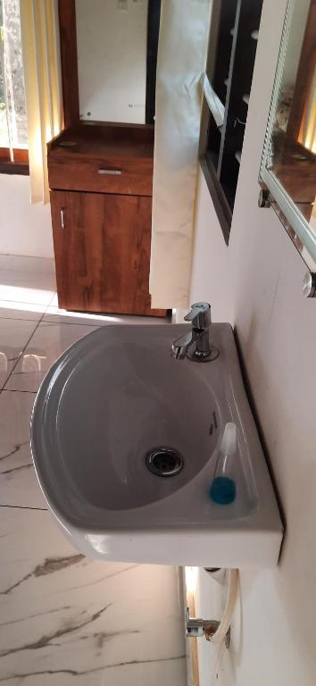 a sink in a bathroom with a mirror at Canan lake home in Parattipalli