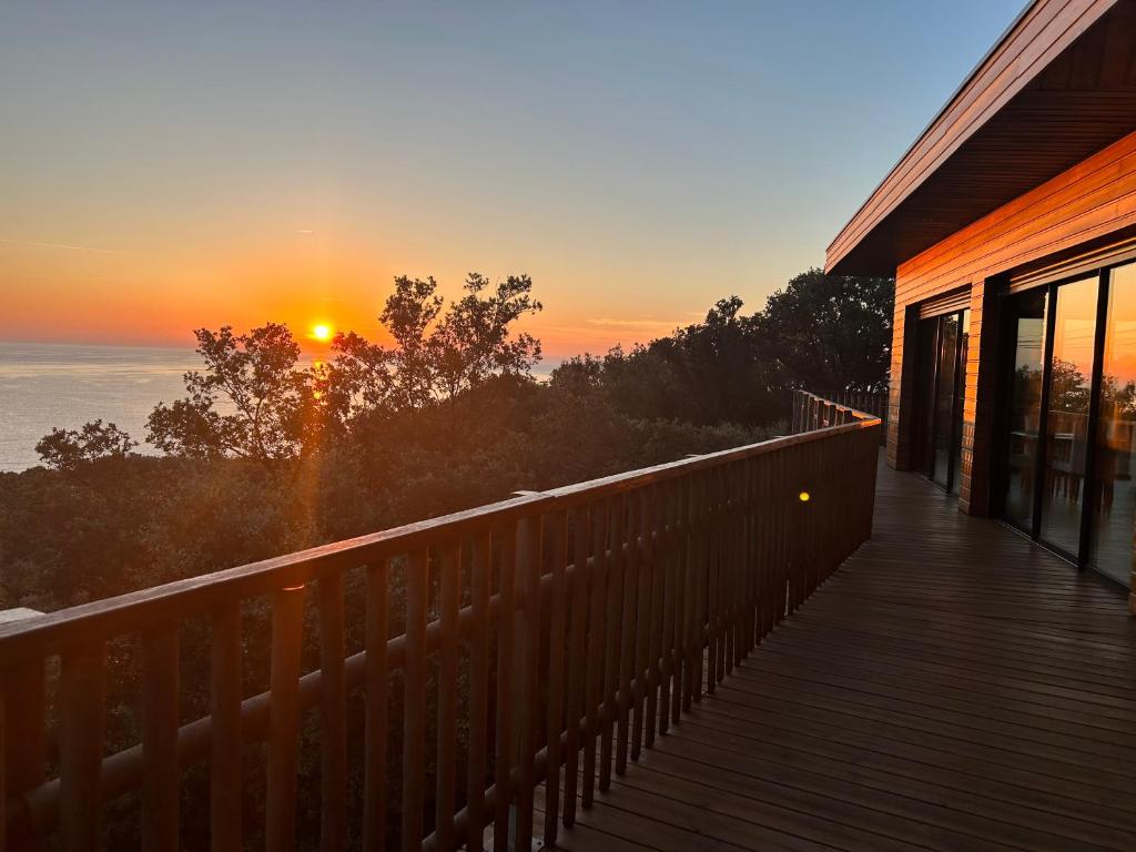 a sunset from a deck of a house at Villa l'Alpana en bois vue mer a 180 degres in Sari Solenzara