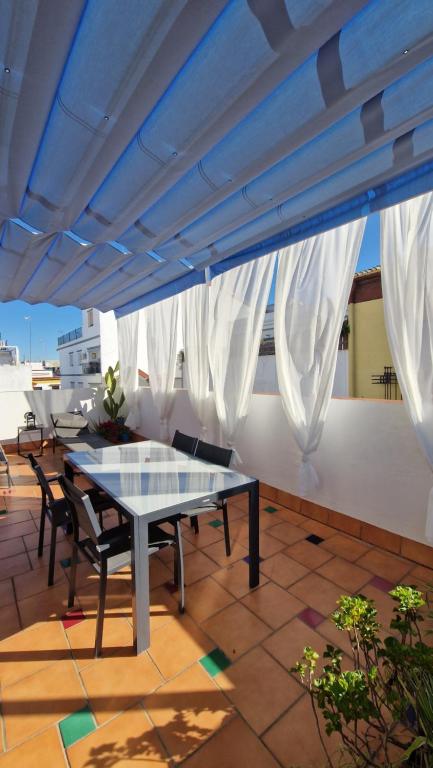 un patio con mesa y sillas en la azotea en Ático la Azotea con terraza PRIVADA, en Sevilla