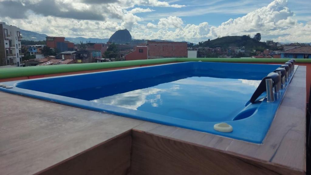 una piscina azul en la azotea de un edificio en ALTO VERDE HOTEL, en Guatapé