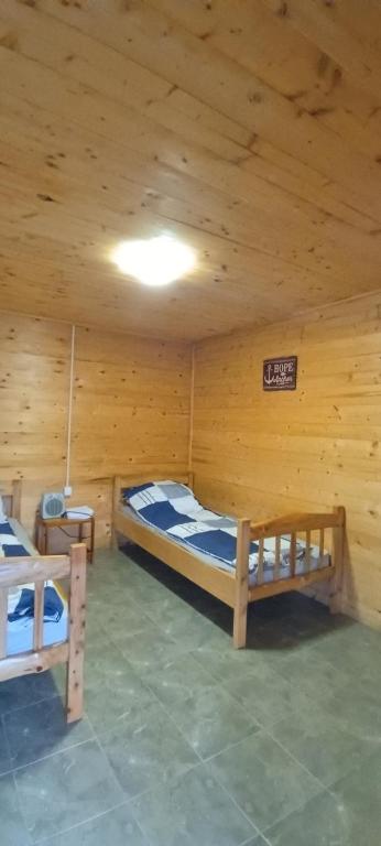 um quarto com 2 camas num chalé de madeira em Drinski Mir em Mali Zvornik
