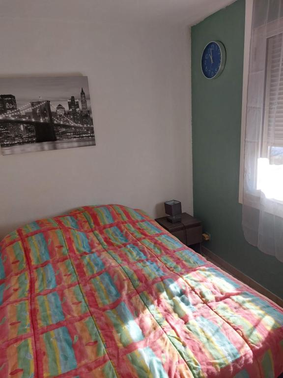 - une chambre avec un lit doté d'une couette colorée dans l'établissement T2 Montpellier plein sud clim wifi terrasse de 16m2, à Montpellier