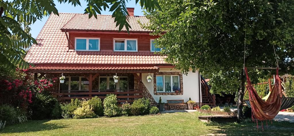 una casa con techo rojo y patio en Agroturystyka U Głuszków, en Myczkowce