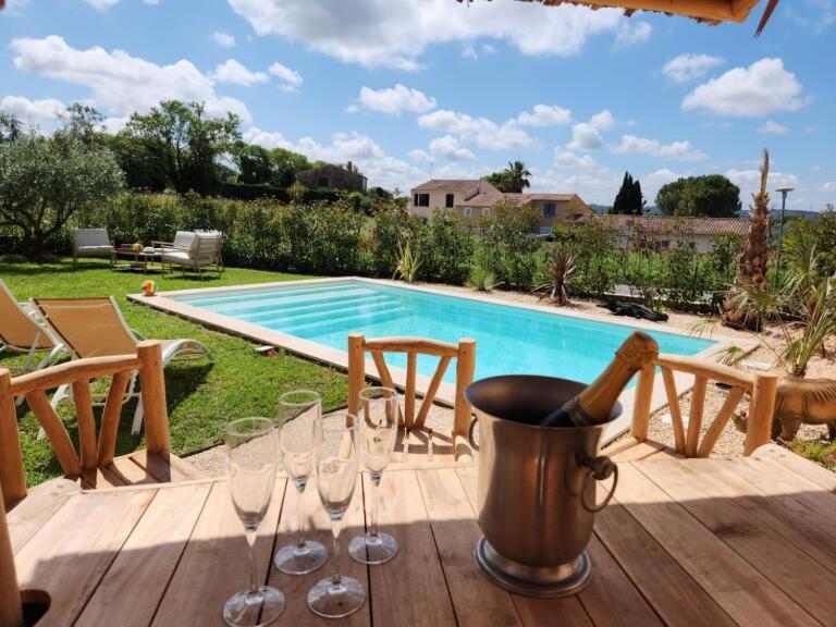 einen Tisch mit Weingläsern und eine Flasche Wein in der Unterkunft Villa Piscine Uzes à pied 6 personnes Farandole in Uzès