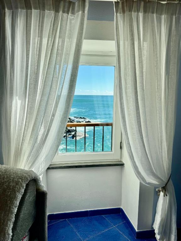 a room with a window with a view of the ocean at La Polena Camere Vernazza - Suite vista mare in Vernazza