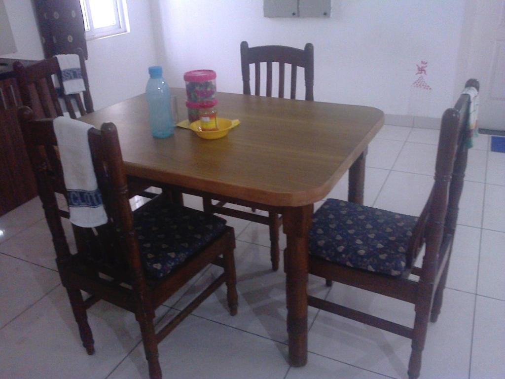 a wooden table with two chairs and a bowl on it at WeKare Archid Royal Service Apartment in Bhubaneshwar