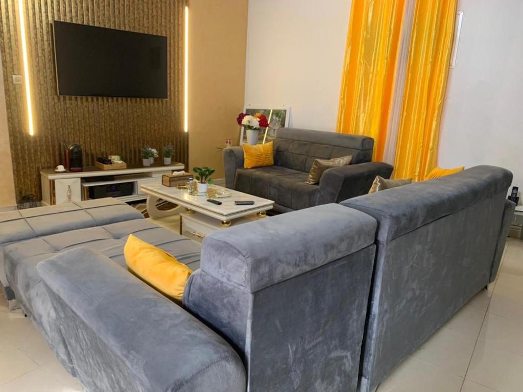 a living room with a couch and a tv at Studio meublé Corniche Mermoz in Dakar