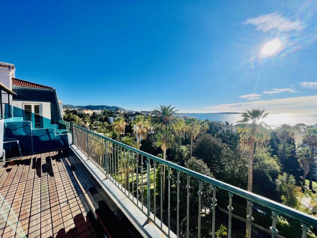 a balcony with a view of the ocean and palm trees at Palais Belle Epoque - Property With Style in Cannes
