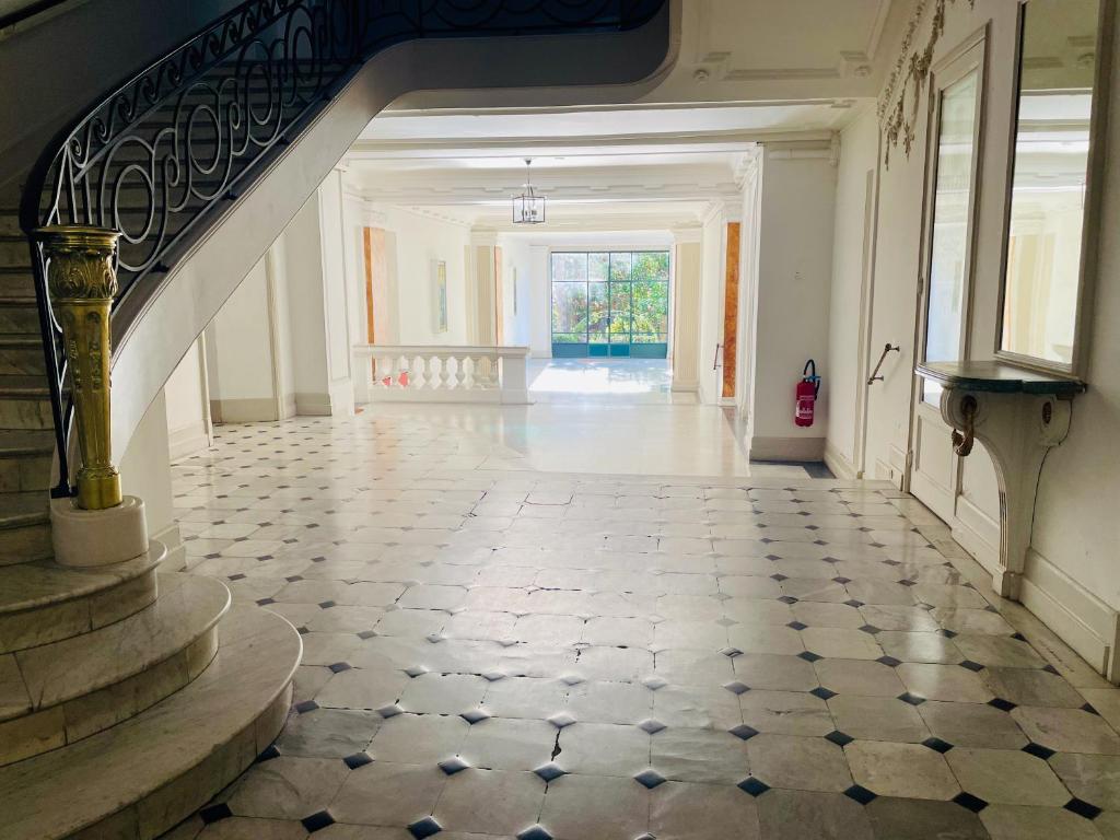 an empty hallway with a staircase and a tile floor at Palais Belle Epoque - Property With Style in Cannes