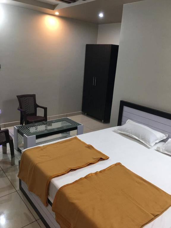 ein Hotelzimmer mit einem Bett, einem Tisch und einem Stuhl in der Unterkunft Ajay Residency and Convention Hall / Lodge Near Me / Lodge Rayachoti in Rāyachoti