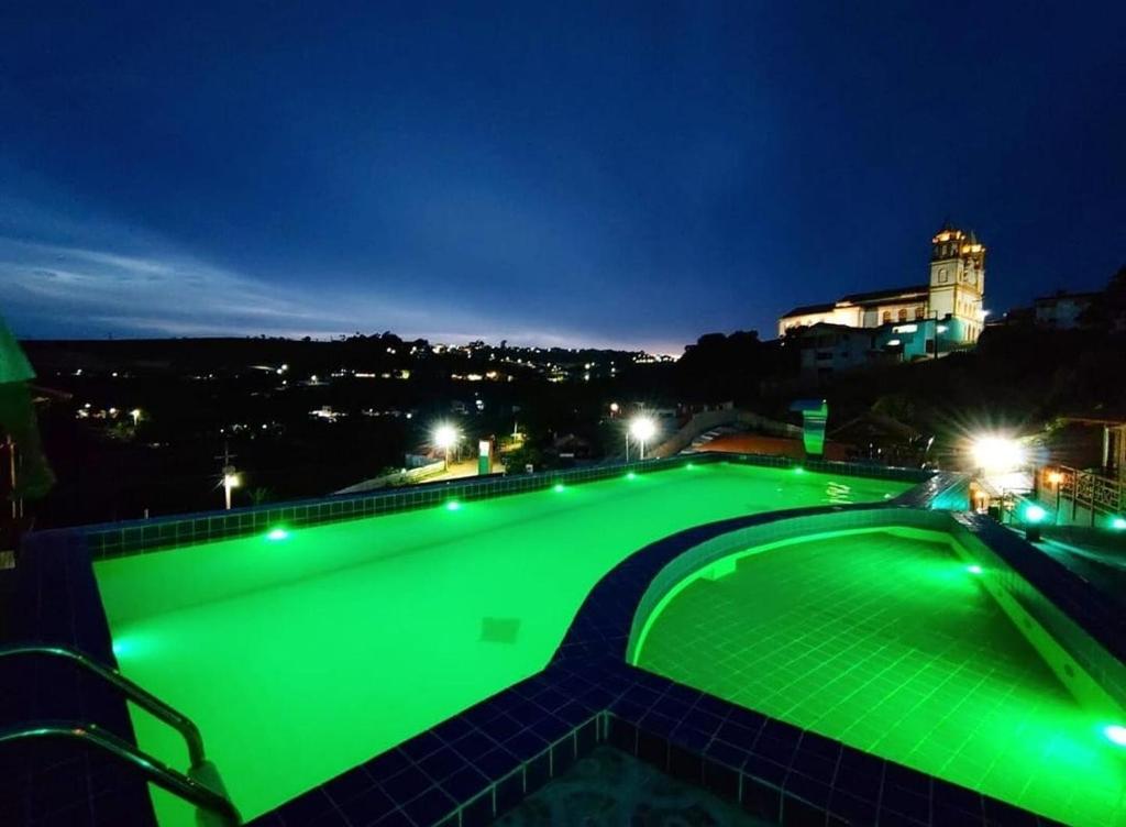 a swimming pool with green illumination at night at CHALES DA SERRA in Bananeiras