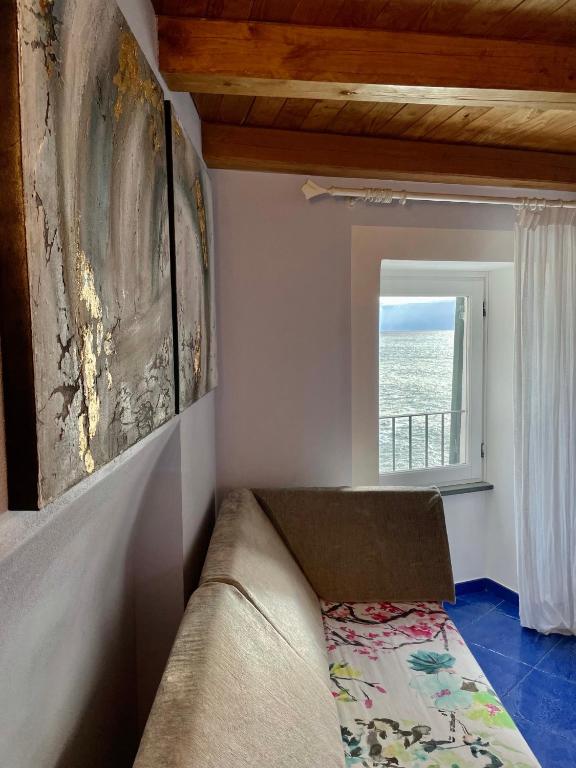 a living room with a couch and a window at La Polena Camere Vernazza - Suite vista mare in Vernazza