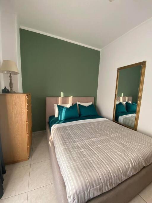 - une chambre avec un lit doté d'oreillers bleus et d'un miroir dans l'établissement Tsaldari center house, à Xánthi