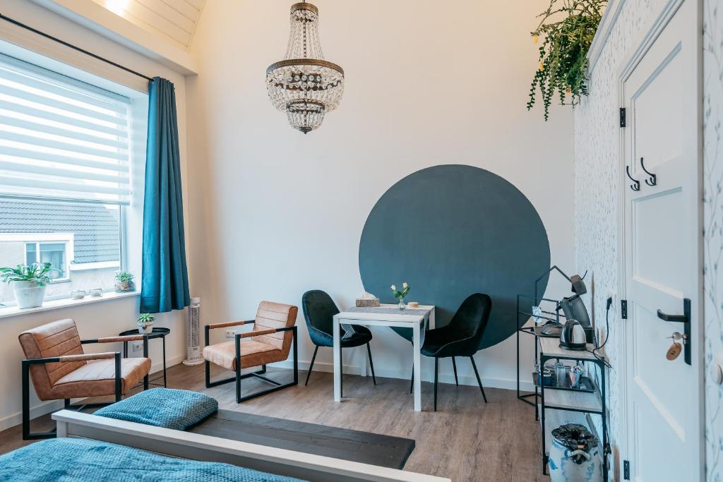 - un salon avec une table et des chaises dans l'établissement Klooster Achthuizen, à Achthuizen