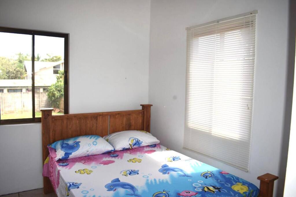 ein Schlafzimmer mit einem Bett mit einem Fenster und einer Tagesdecke mit Delfinen in der Unterkunft Alojamiento Casmar cerca de playas in Palma