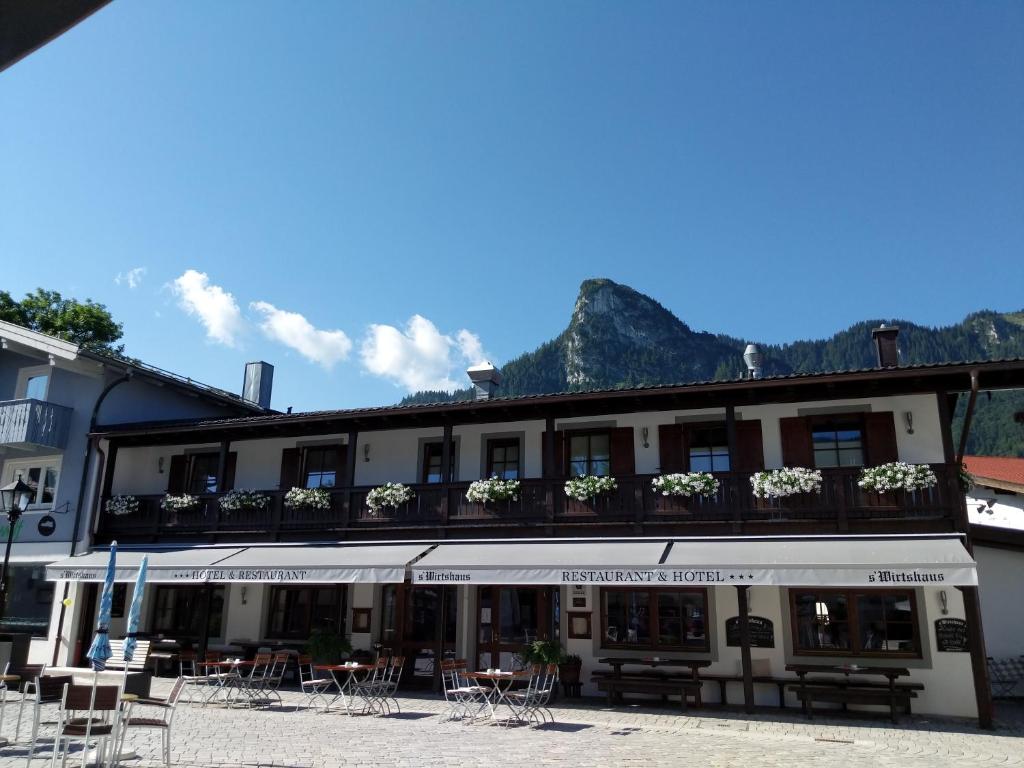 a building with tables and chairs in front of it at s`Wirtshaus Hotel & Restaurant in Oberammergau