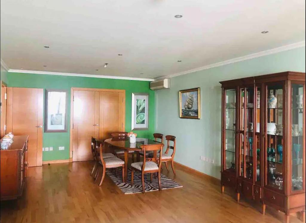 a dining room with a table and chairs and green walls at APARTMENT IN OCEAN VILLAGE, SLEEPS UP TO 6 in Gibraltar