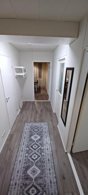 an empty hallway with a rug on a wooden floor at RELAX in Kemi near the sea in Kemi