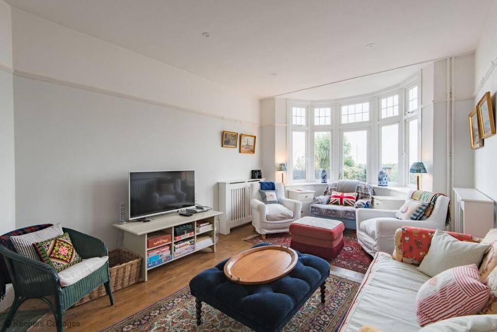 een woonkamer met meubilair en een televisie bij Bayside House in Westgate-on-Sea