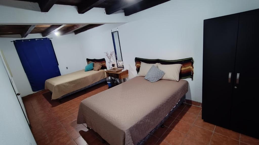 a bedroom with two beds in a room at Hotel Posada Don Papagon in Antigua Guatemala