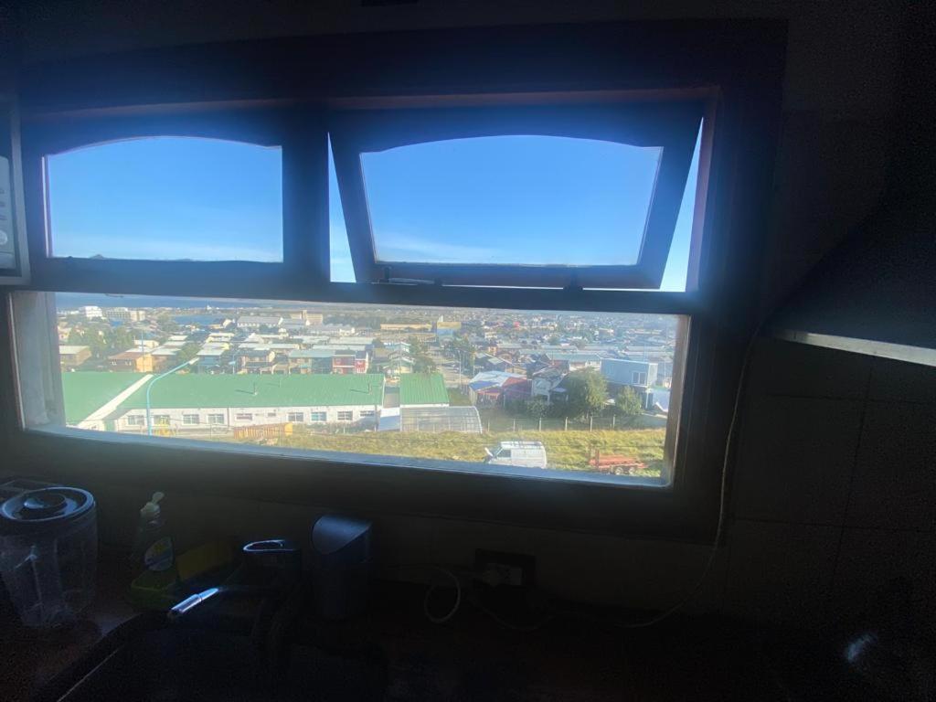 drie ramen in een kamer met uitzicht op de stad bij Ohana in Ushuaia