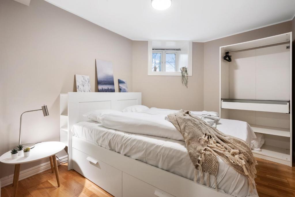 a white bedroom with a bed and a table at New! Modern City Apt: Central w/ Private Entrence in Bergen