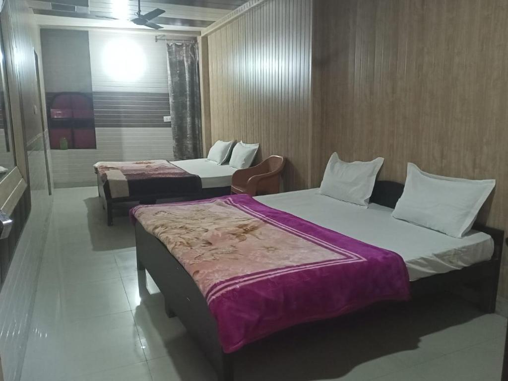 een hotelkamer met 2 bedden en een badkamer bij Aapka Ghar Guest House in Bhīm Tāl