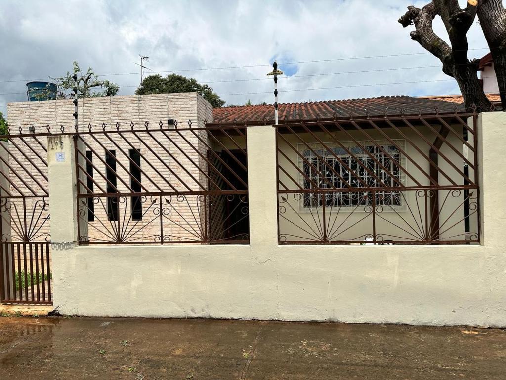 a gate on a white building with a fence at Acogedora Casa Céntrica in Ciudad del Este
