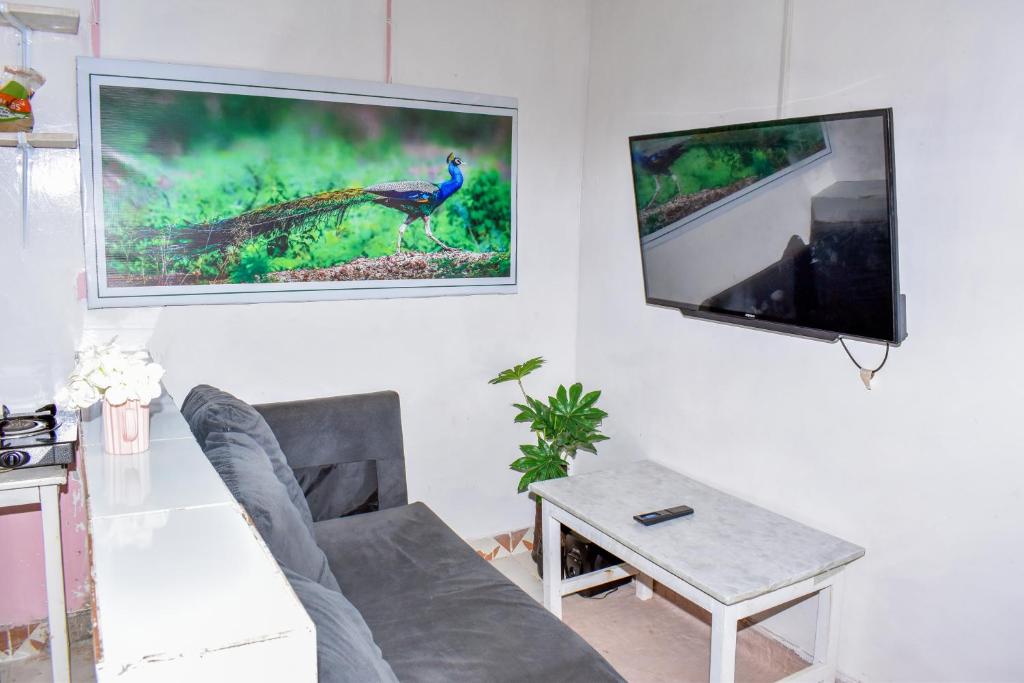 sala de estar con sofá y TV de pantalla plana en Minari Holiday Homes, en Bungoma