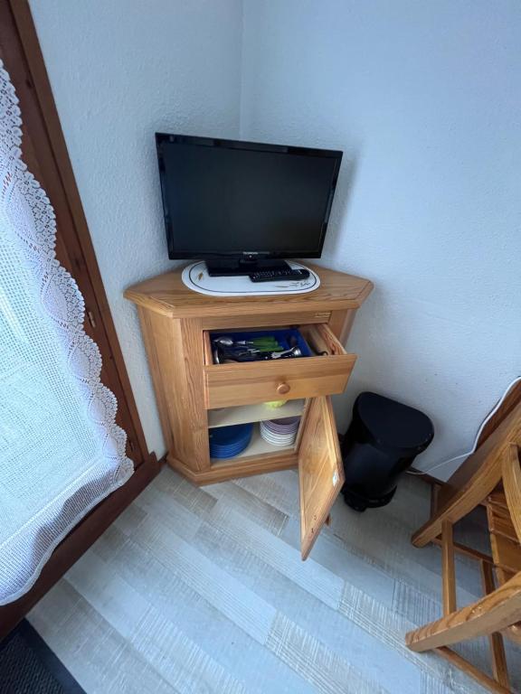 a small wooden table with a television on it at Aux pieds des pistes en plein soleil in Les Contamines-Montjoie