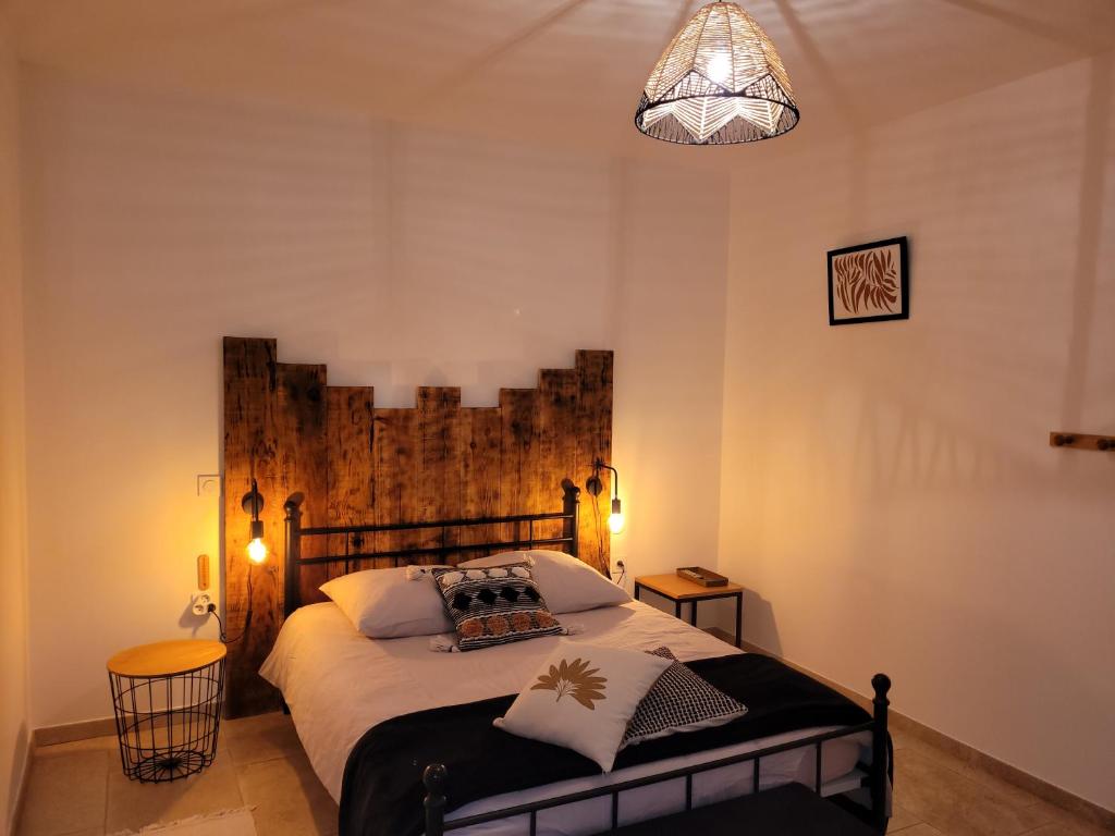 Lasséran的住宿－La Gurlanne，一间卧室配有一张大床和木制床头板