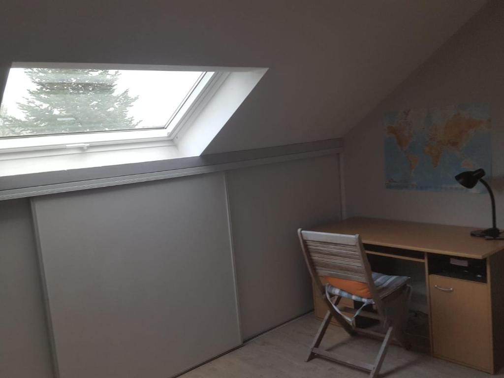 Cette chambre mansardée comprend un bureau et une fenêtre. dans l'établissement Chez Fabrice, à Nantes