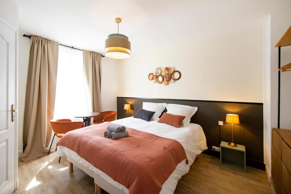 une chambre avec un grand lit avec une couverture rouge dans l'établissement Loire - Hypercentre, à Orléans