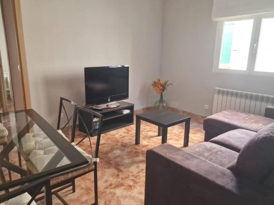 Una sala de estar con un sofá y un televisor de pantalla plana. en Casa Azañas, en Casavieja