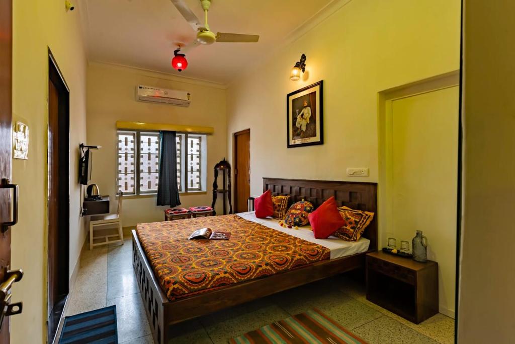 a bedroom with a large bed with red pillows at Matra Chaya in Jodhpur