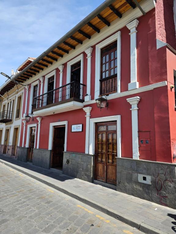 un edificio rojo y blanco en una calle en Casa Hibiscus Boutique Hotel en Cuenca
