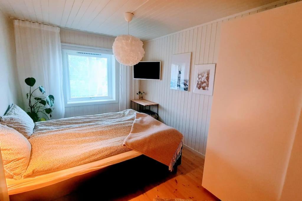 1 dormitorio con cama y ventana en Private Mountain Apartment, en Narvik