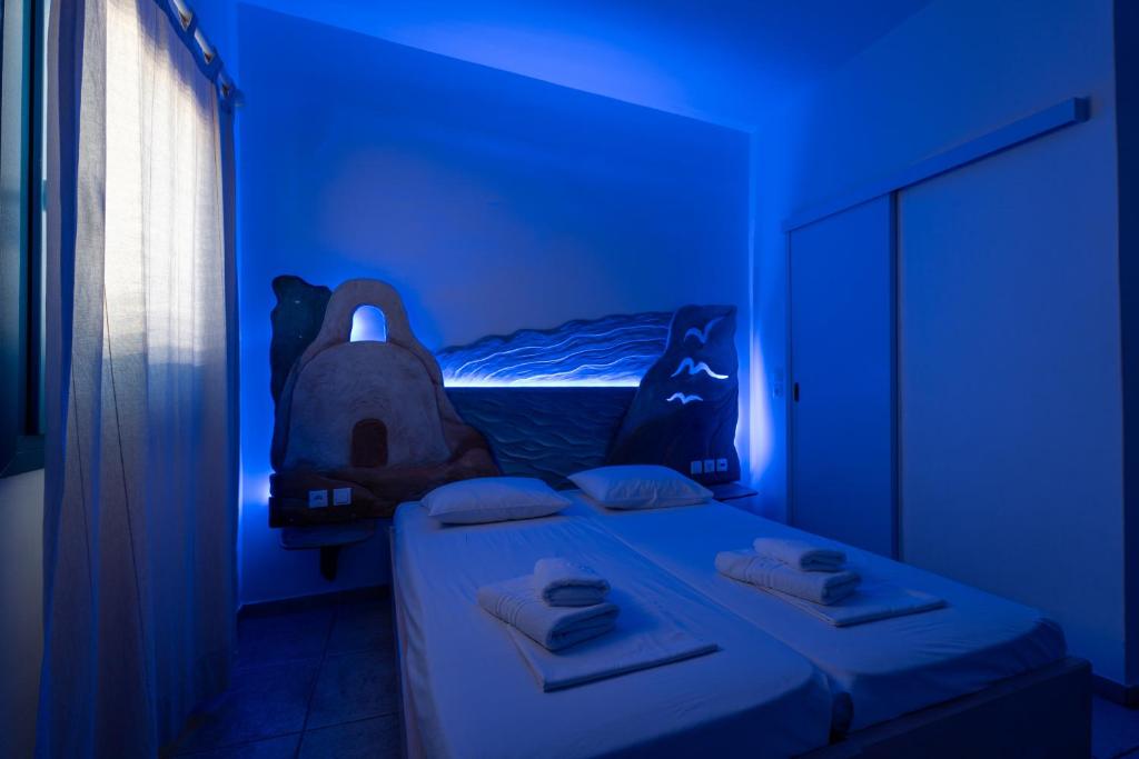 a blue room with two beds and a window at Fanari Art in Ios Chora