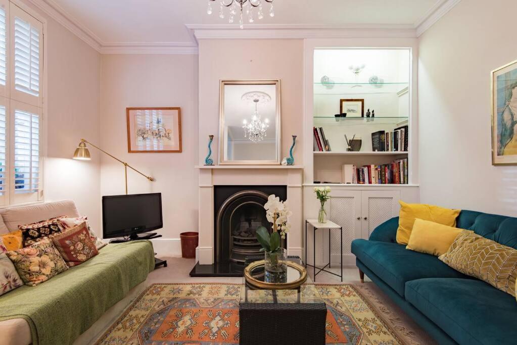 a living room with a couch and a fireplace at Villa Vita - Ideally located cottage by the sea in Deal