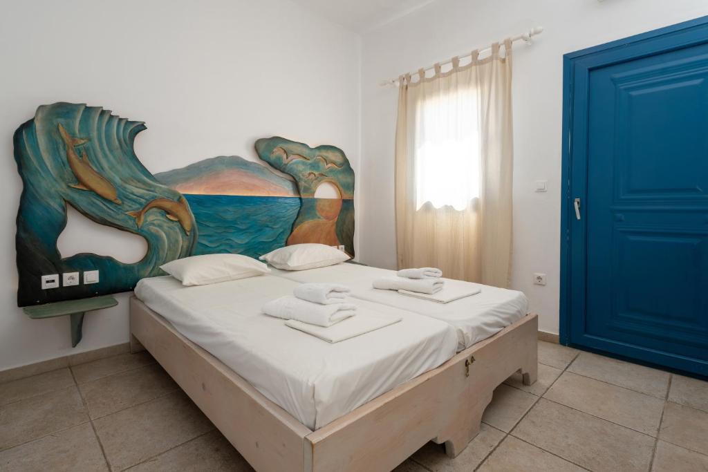 a bedroom with a bed with a painting on the wall at Fanari Art in Ios Chora