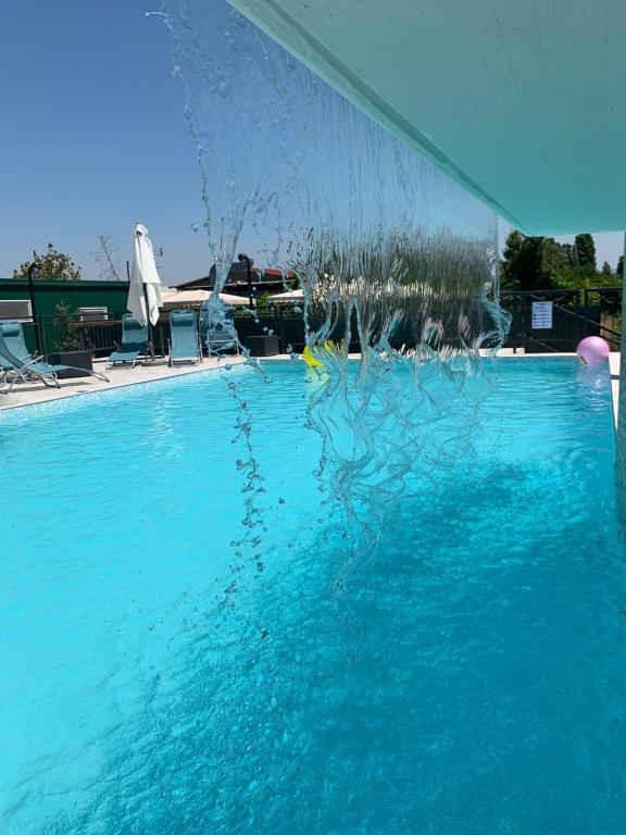 a blue swimming pool with a water fountain at Villa Patrizia in Mostacciano 