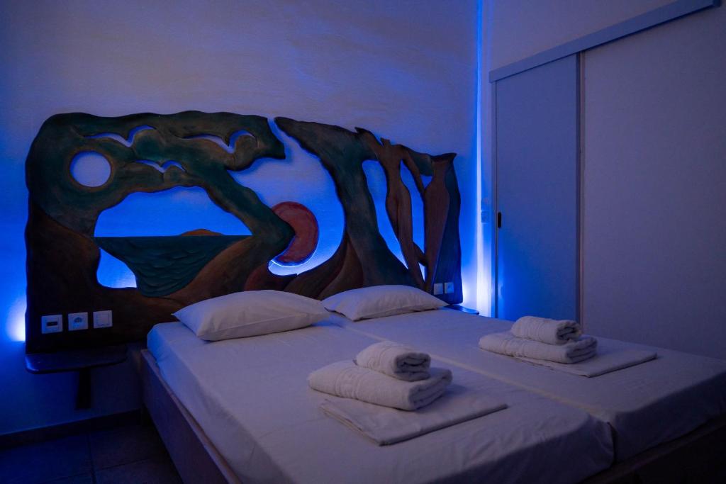 a bedroom with a bed with a wooden head board at Fanari Art in Ios Chora