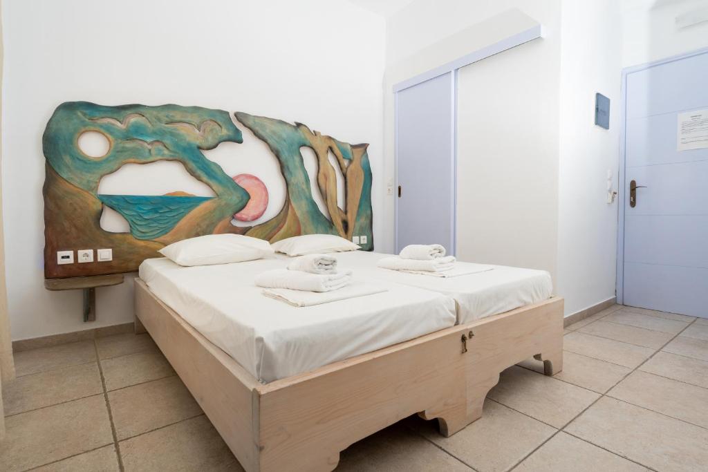 a bedroom with a bed with a painting on the wall at Fanari Art in Ios Chora