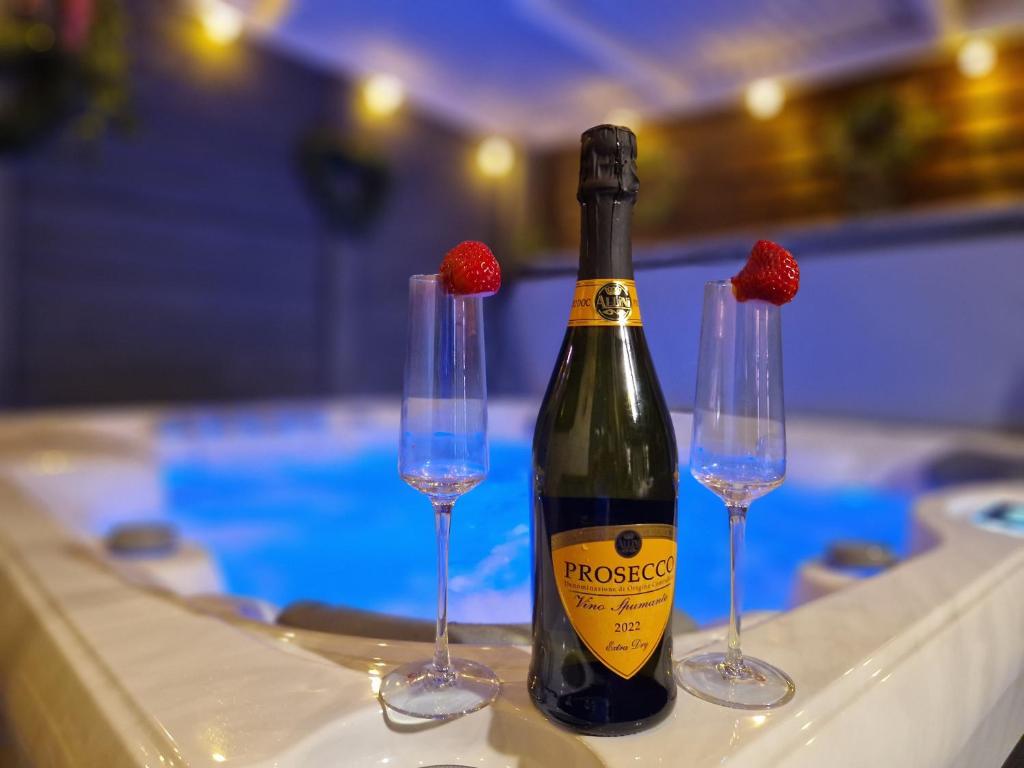 una bottiglia di champagne e due bicchieri con fragole sopra di The Log Cabin a Waterford